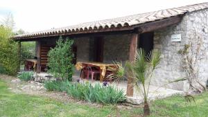 a stone cabin with a wooden table in front of it at Maisonette Mirabel 1, 6 Pers, Domaine De Ribiere in Grospierres