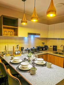 a kitchen with a table with plates and wine glasses at Confort & luxury Apt- San Isidro in Lima