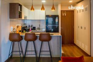 a kitchen with three bar stools at a counter at Confort & luxury Apt- San Isidro in Lima
