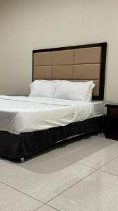 a large bed in a bedroom with a headboard at الشمائل الراقيه للشقق المخدومة in Taif