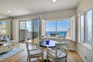 a dining room with a table and chairs with a view of the ocean at Beachfront Sunset in Encinitas