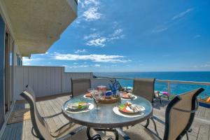 a table on a balcony with a view of the ocean at Beachfront Sunset in Encinitas