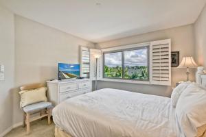 a bedroom with a white bed and a window at Beachfront Sunset in Encinitas