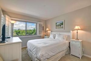 a bedroom with a white bed and a window at Beachfront Sunset in Encinitas