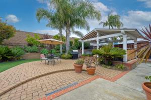 a patio with a table and chairs and an umbrella at Carlsbad Charm - 3BR Stunner in Carlsbad