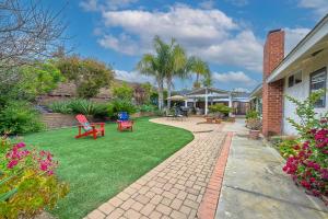 a backyard with a lawn with chairs and tables at Carlsbad Charm - 3BR Stunner in Carlsbad
