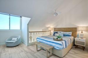 a bedroom with a bed and a blue chair at Seaside Sunset in Carlsbad