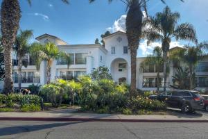 Un coche aparcado delante de un edificio con palmeras. en Southern Exposure with Private Balcony, en Carlsbad