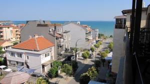 a city street with buildings and the ocean in the background at Gnezdo Apartment Sarafovo in Burgas City