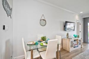 a dining room with a glass table and white chairs at La Costa Gem - Condo for 3 in Carlsbad +27 photos