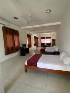 ein großes Schlafzimmer mit 2 Betten und einem Schreibtisch in der Unterkunft Casa Donde Entra la Luz y Vive la Naturaleza CCTV in Cozumel