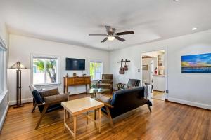 ein Wohnzimmer mit einem Deckenventilator und einem Tisch in der Unterkunft Vintage Beach Bungalow - For 6 in Oceanside + 33 Fotos