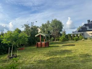 a garden with a gazebo in the grass at Jesionowy domek in Augustów +9 photos