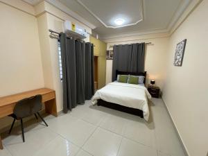 a bedroom with a bed and a desk and a chair at Eden Court Luxe in Ogbojo
