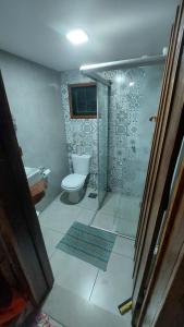 a bathroom with a toilet and a glass shower at Pousada Casa do Arco in Santana do Riacho +60 photos