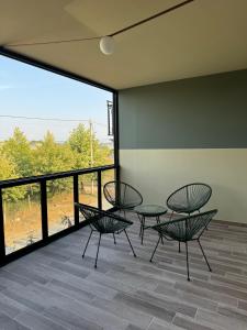 een kamer met stoelen en tafels en een groot raam bij Lidova Apartments in Hamallë