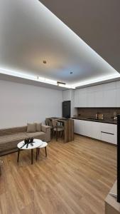 een woonkamer met een bank en een tafel bij Lidova Apartments in Hamallë
