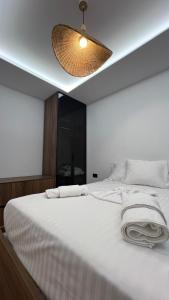 een slaapkamer met een groot wit bed en een licht bij Lidova Apartments in Hamallë