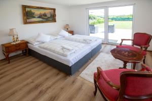 a bedroom with a bed and a table and chairs at Apartman louis A102 in Tomášikovo