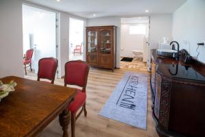 a living room with a desk and chairs and a table at Apartman louis A102 in Tomášikovo