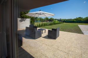 a patio with two chairs and an umbrella at Apartman louis A102 in Tomášikovo