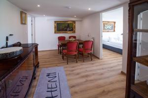 a dining room with a table and red chairs at Apartman louis A102 in Tomášikovo