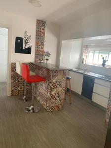 kuchnia z blatem i czerwonym stołkiem w obiekcie Vivienda Turística Níjar w mieście Níjar