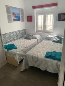 sypialnia z dwoma łóżkami i oknem w obiekcie Vivienda Turística Níjar w mieście Níjar