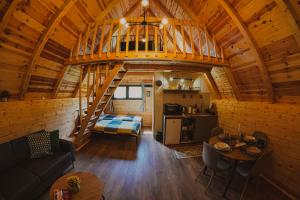 a large room with a staircase in a log cabin at Javorje24 chalets in Žabljak +27 photos