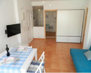 a living room with a table and a blue couch at Piso Playa de Canet in Canet de Berenguer
