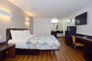 a small hotel room with a bed and a desk at Motel 6-Hamburg, NY in Hamburg