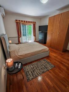 Un dormitorio con una cama y una ventana grande. en Casa Jugueiros, en Viseu