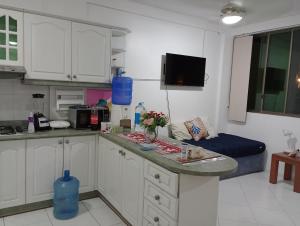 a kitchen with white cabinets and a blue counter top at Playa Costa Azul Tonsupa- Esmeraldas in Volcán Chimborazo