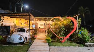 an old car parked outside a house with a heart sign at Eco Hotel Villa Canaan in Cobán