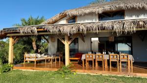 Un restaurante con mesas y sillas y techo de paja. en Villa Amazi, en Andilana