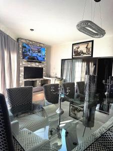 バンダービールパークにあるZee Lifestyle Guesthouseのガラスのテーブルと椅子のあるリビングルーム