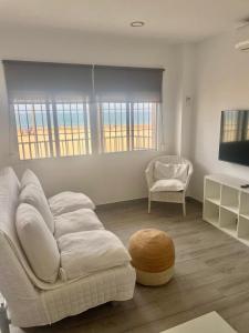 a living room with a white couch and a television at Córdoba 8 by 7Escalones in Rota