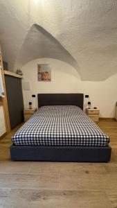 a bedroom with a bed with a black and white comforter at Coriva Homes Cogolo in Cogolo