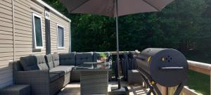 a patio with an umbrella and a grill at Chalet De Bosrand Gasselte in Gasselte