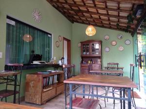 a dining room with tables and chairs and a counter at Pousada Cigarras da Serra in Serra do Cipo