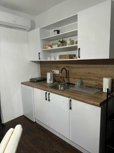 a kitchen with white cabinets and a sink at Cottage Arinda in Jajce