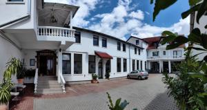 a white building with a car parked in front at Villa Santa Maria in Sibiu