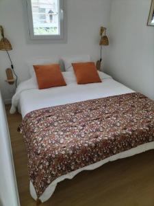 a bedroom with a large bed with a blanket on it at Appartement Grande Plage St Gilles Croix de Vie - Parking privé in Saint-Gilles-Croix-de-Vie