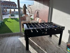 a black foosball table in front of a window at Pisos viajer@s in O Grove +47 photos