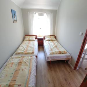 two beds in a room with a window at Apartamenty Afrodyta in Karwia