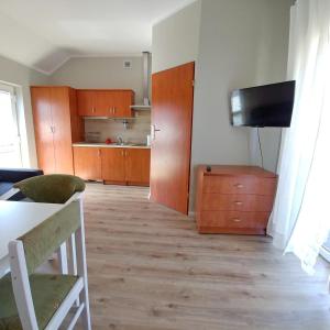 a living room with a television and a kitchen at Apartamenty Afrodyta in Karwia