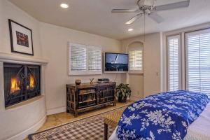 a bedroom with a fireplace and a bed and a tv at Luxurious Mykonos in Santa Barbara with Outdoor Deck Short Bike Ride to Beach in Santa Barbara +13 photos
