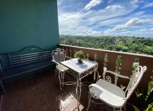 a table and chairs on a balcony with a view at Crosswinds 1BR Suite, 50"QLED TV, BIG Balcony View in Ulot