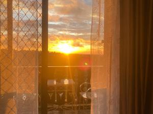 a sunset seen through a window with a view at Crosswinds 1BR Suite, 50"QLED TV, BIG Balcony View in Ulot +41 photos