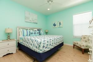 - une chambre avec des murs bleus, un lit et une chaise dans l'établissement Pet Friendly Shared Pool Sleeps 14, à Port Aransas